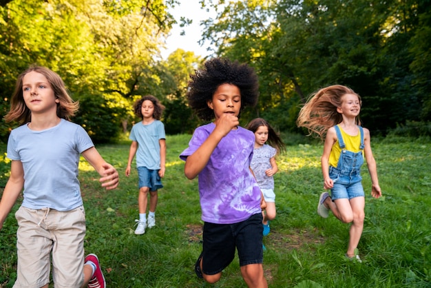 Niños de vista frontal corriendo al aire libre