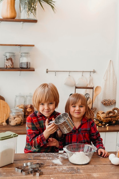 Niños de vista frontal haciendo galletas de Navidad