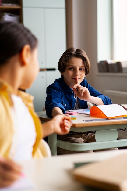 Foto gratuita niños de vista frontal haciendo trampa en la escuela