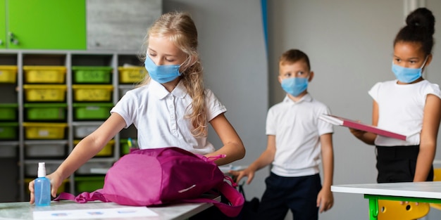 Niños de vista frontal preparándose para dejar la escuela