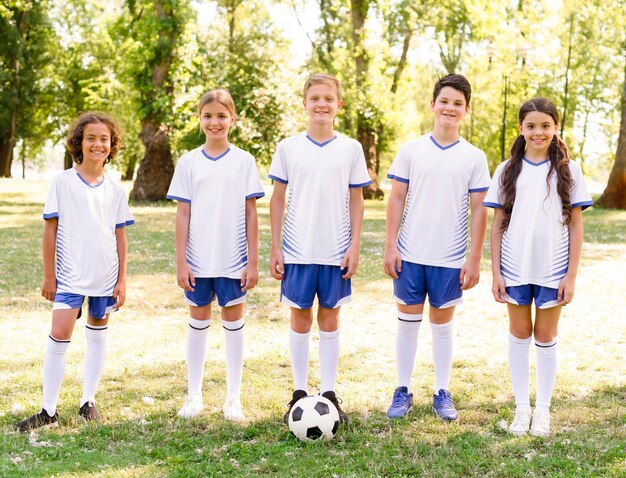 Niños de vista frontal preparándose para jugar un partido de fútbol