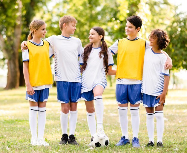 Niños de vista frontal en ropa deportiva de fútbol mirando el uno al otro