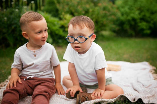 Foto gratuita niños de vista frontal sentados al aire libre