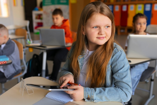 Foto gratuita niños de vista lateral aprendiendo en la escuela