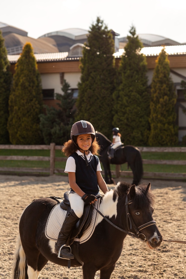 Foto gratuito niños de vista lateral aprendiendo a montar a caballo.