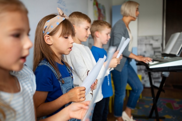 Niños de vista lateral cantando juntos en la escuela dominical