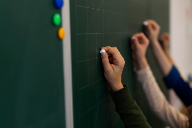 Foto gratuita niños de vista lateral escribiendo a bordo