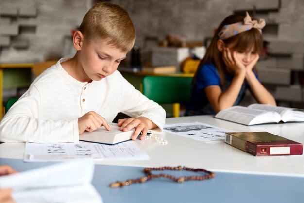 Niños de vista lateral estudiando la biblia