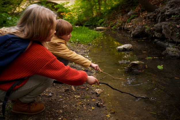 Niños de vista lateral explorando la naturaleza juntos