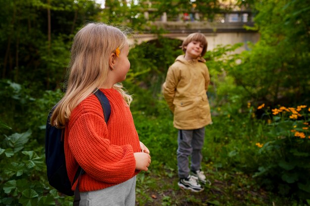 Niños de vista lateral explorando la naturaleza juntos