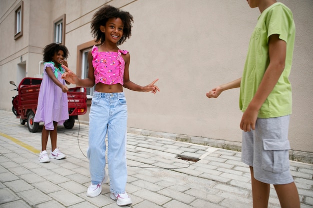 Foto gratuita niños de vista lateral jugando juntos al aire libre