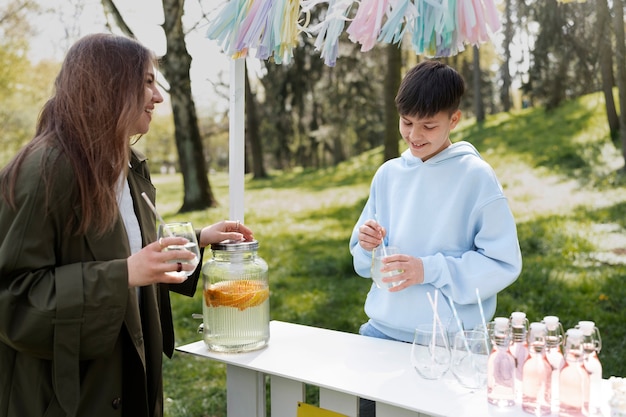 Foto gratuita niños de vista lateral en el puesto de limonada