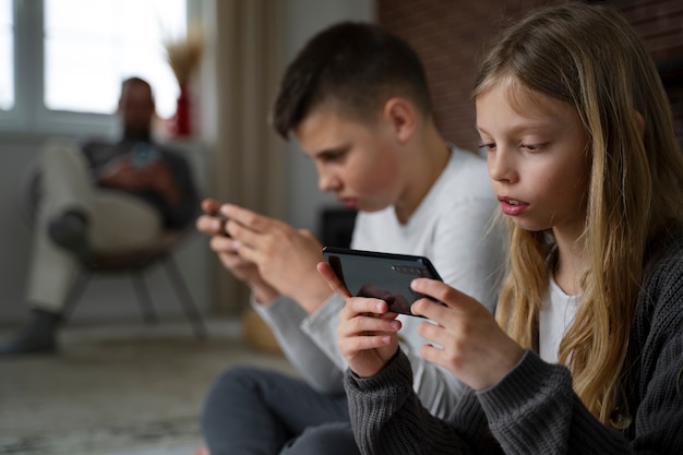 Niños de vista lateral con teléfonos inteligentes