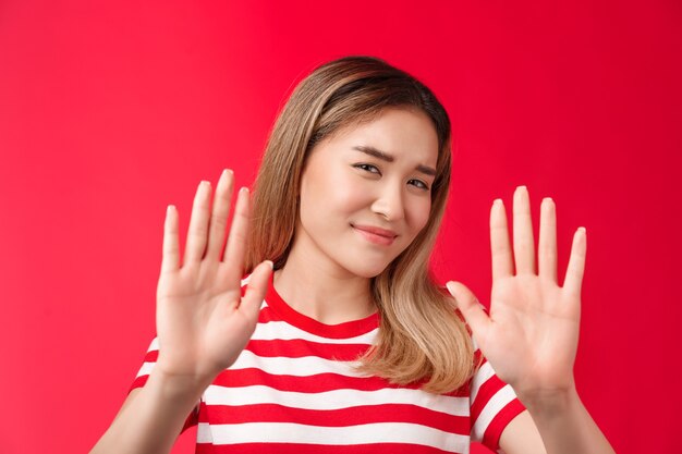 No, gracias paso renuente perezoso lindo asiático moderno chica mostrar manos bloquear gesto de rechazo sonriendo ...