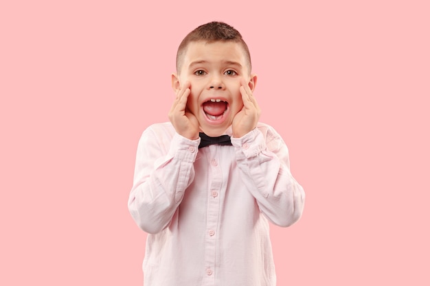 Foto gratuita no te pierdas. chico joven casual gritando. gritar. adolescente emocional llorando gritando sobre fondo rosa de estudio. el retrato masculino de medio cuerpo. las emociones humanas, el concepto de expresión facial. colores de moda