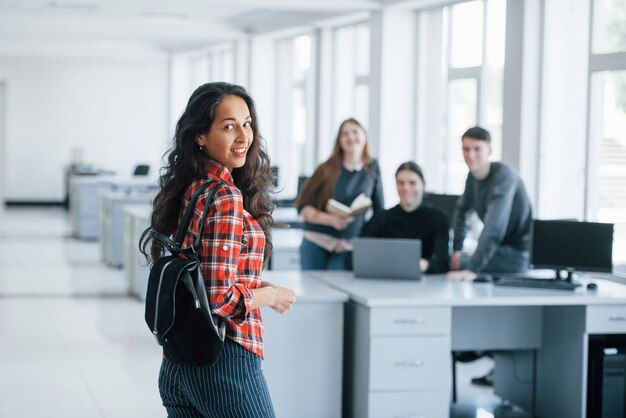 No te vi allí. Grupo de jóvenes en ropa casual que trabajan en la oficina moderna