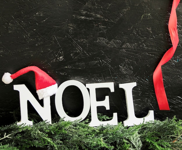 Noel inscripción con gorro de santa