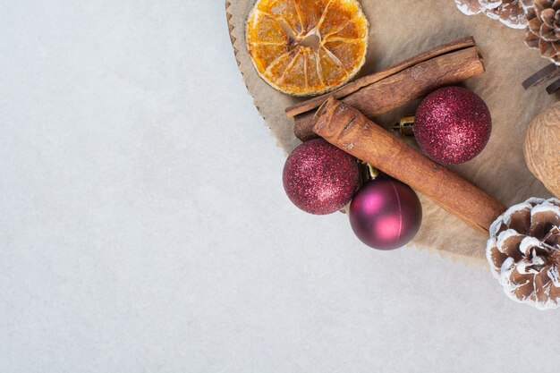 Nogal con piñas y bolas de Navidad en plato de madera. Foto de alta calidad