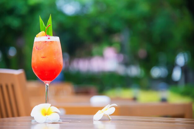 El nombre de la receta del cóctel mai tai o mai thai cóctel mundial incluye ron, jugo de limón, jarabe de orgeat y licor de naranja - bebida alcohólica dulce con flor en el jardín, concepto de vacaciones de relax