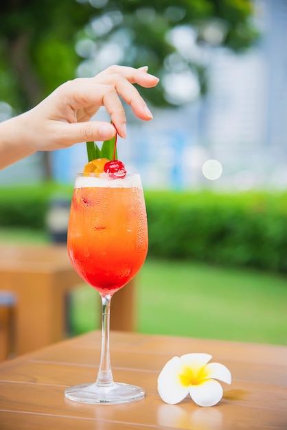 El nombre de la receta del cóctel mai tai o mai thai cóctel mundial incluye ron, jugo de limón, jarabe de orgeat y licor de naranja - bebida alcohólica dulce con flor en el jardín, concepto de vacaciones de relax