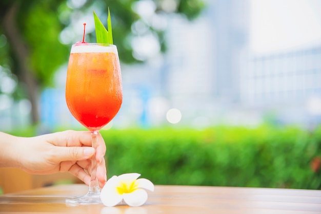 El nombre de la receta del cóctel mai tai o mai thai cóctel mundial incluye ron, jugo de limón, jarabe de orgeat y licor de naranja - bebida alcohólica dulce con flor en el jardín, concepto de vacaciones de relax