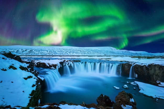 Northern Light, Aurora borealis en la cascada Godafoss en invierno, Islandia.
