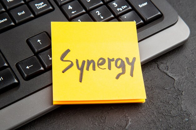 Nota adhesiva con la palabra Synergy sobre el teclado