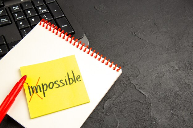 Notas de motivación con la palabra imposible sobre portátil
