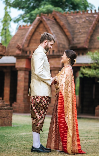 Novia asiática y novio caucásico tienen tiempo romántico con vestido de Tailandia