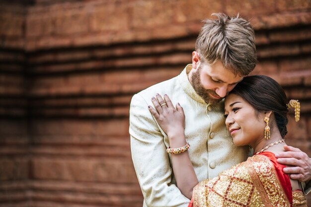 Novia asiática y novio caucásico tienen tiempo romántico con vestido de Tailandia