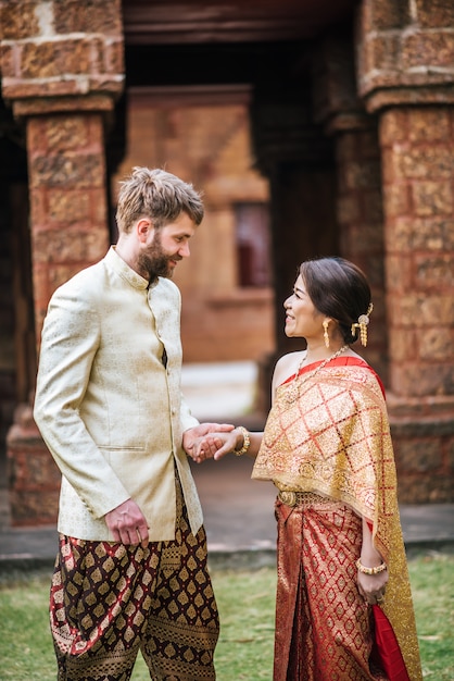 Novia asiática y novio caucásico tienen tiempo romántico con vestido de Tailandia