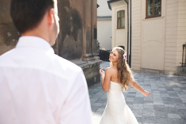 Novia bailando en la calle mientras su marido mira