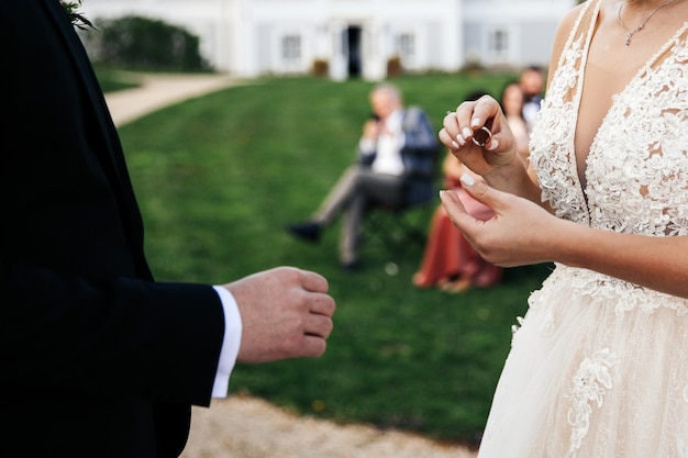 La novia va a colocar el anillo de bodas en el dedo del novio