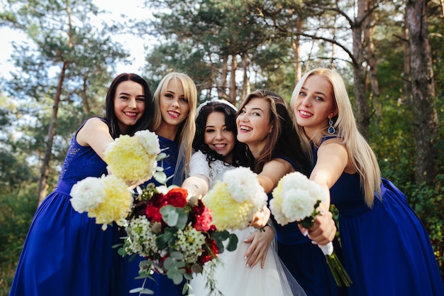 Novia con damas de honor sosteniendo ramos posando