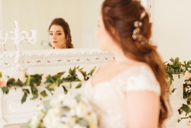 Novia elegante mirando su reflejo