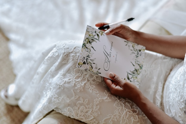 La novia está escribiendo los votos matrimoniales, los símbolos del día de la boda