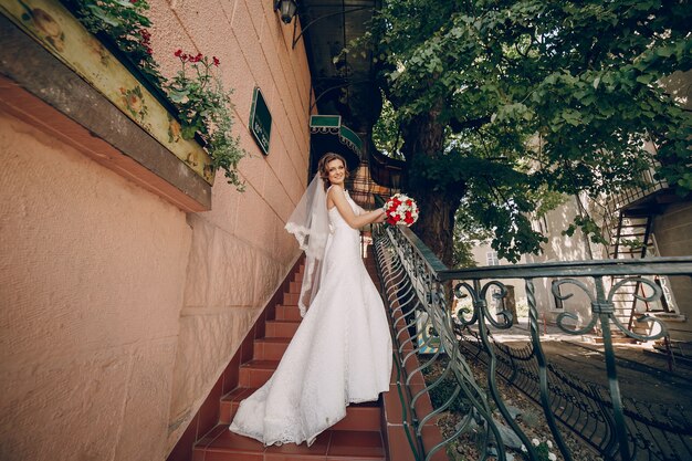 Novia feliz posando en las escaleras