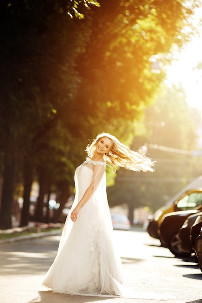 Novia feliz posando con su vestido de novia blanco