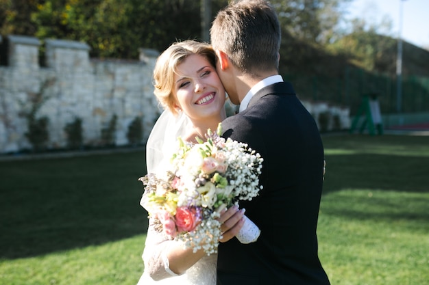 Foto gratuita novia feliz con su marido y un ramo de flores