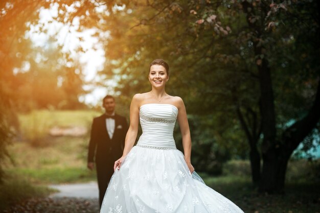 Novia joven feliz caminando por el parque