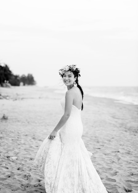 Novia joven en su vestido de novia en la playa