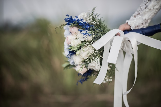 Novia mano que sostiene la flor en el día de la boda