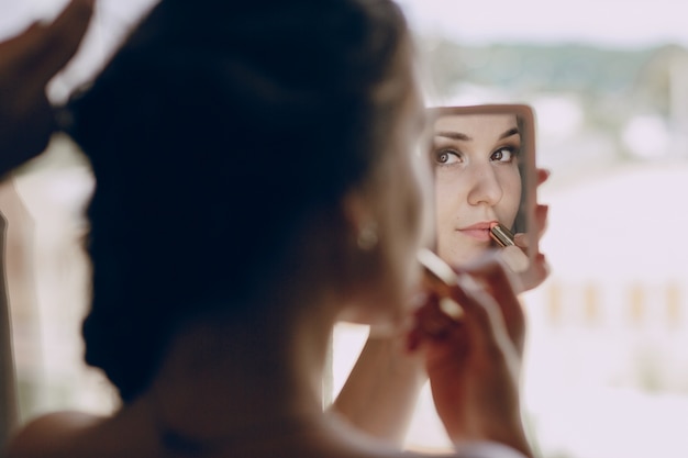 Novia maquillándose en un espejito