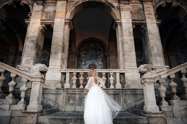 Novia en media vuelta se encuentra en las escaleras del antiguo edificio