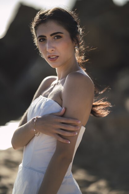 Novia morena caucásica posando durante la boda en la playa