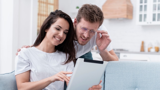 Novia mostrando a su novio algo en una tableta