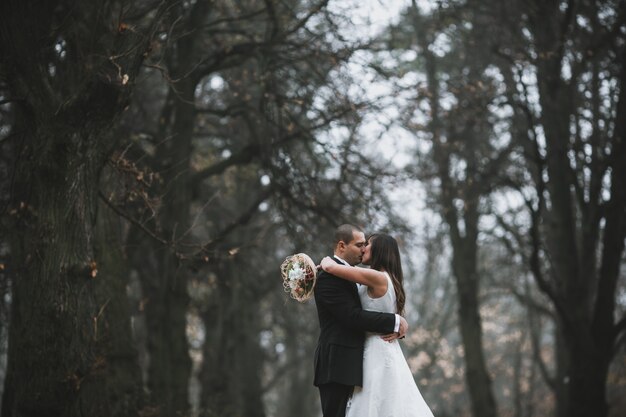 Novia y el novio besándose en los bosques