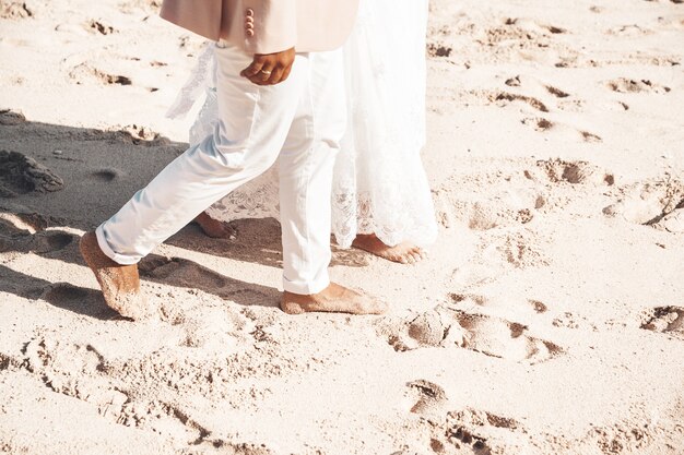 Novia y el novio caminando juntos por la playa. Pareja de novios románticos