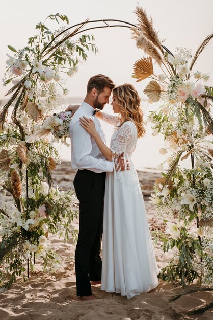 La novia y el novio celebrando su boda en la playa.