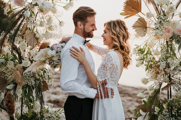 Foto gratuita la novia y el novio celebrando su boda en la playa.